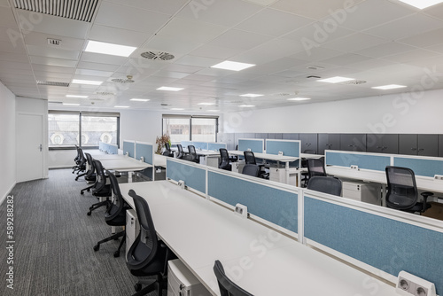Spacious gray office with long tables and chairs in front of the opening of the training and seminar center waiting for the students. Concept of commercial spaces in the city center