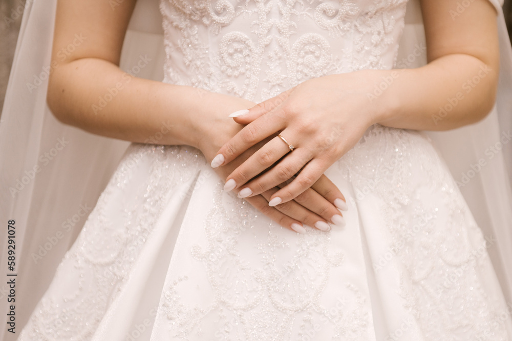 The bride's hands with a beautiful manicure and a diamond ring The bride's hands with a beautiful manicure and a diamond ring