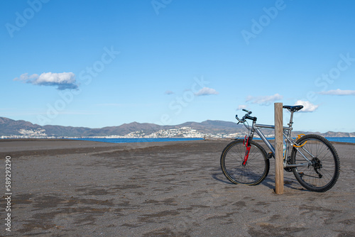 mountain bike leaning on a wooden post on the beach of sant pere pescador girona catalonia spain