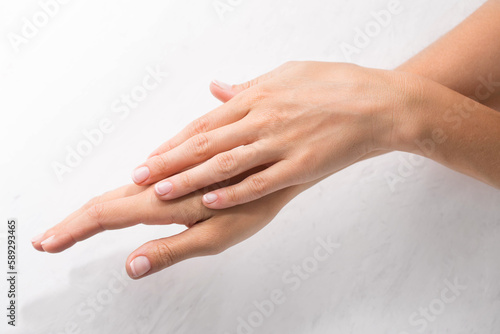 Female hands with minimalist manicure on white background