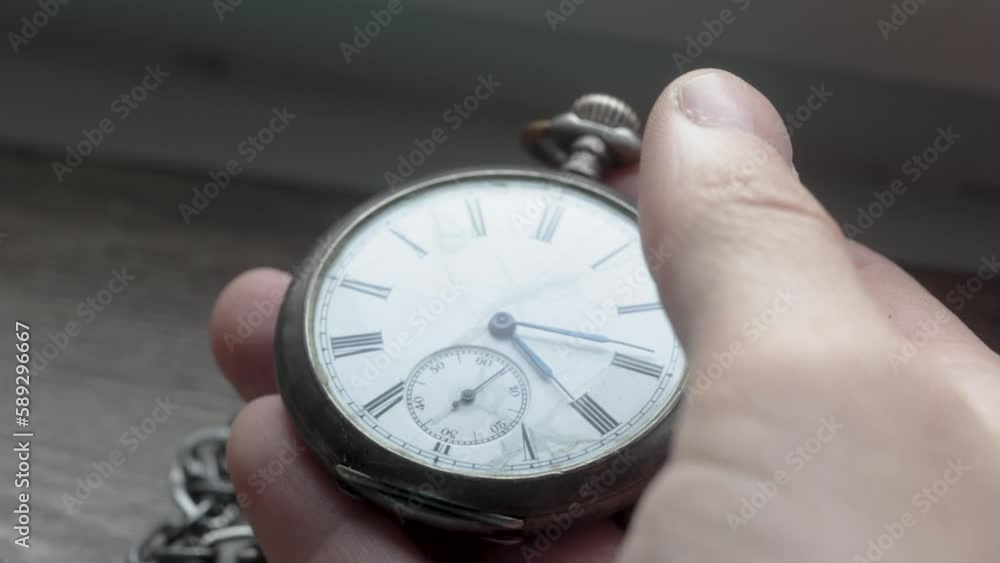 hand raises a pocket watch into frame and opens it before closing it back up hand raises a pocket watch into frame and opens it before closing it back up