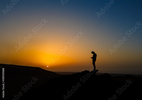 Fototapeta Naklejka Na Ścianę i Meble -  Controlling a drone to capture a beautiful warm sunset photograph near Corralejo in Fuerteventura Spain