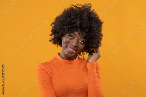 Beauty young woman in orange golf on isolated yellow background.