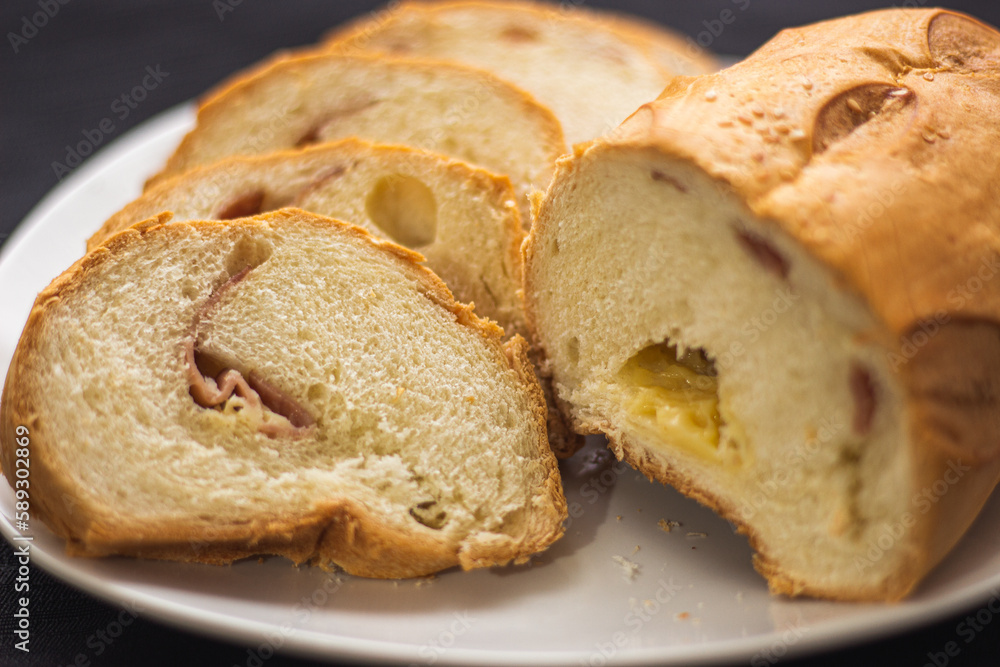 pan de jamón y queso casero y fresco partido en rodajas sobre un plato.
