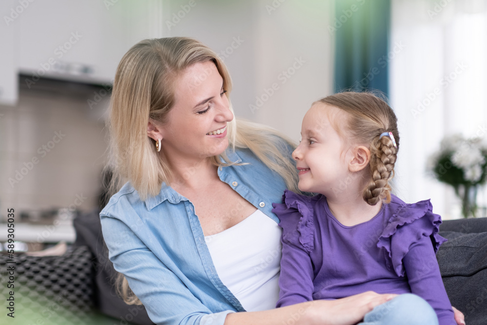 pretty little girl and her mother spending happy sunny morning at home together. mom and daughter looking to each other smiling and cuddling pretty little girl and her mother spending happy sunny morning at home together. mom and daughter looking to each other smiling and cuddling