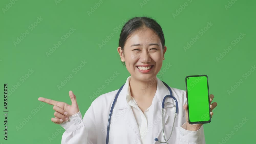 Close Up Of Asian Woman Doctor With Stethoscope Smiling And Showing Green Screen Smartphone While Standing On Green Screen Background In The Hospital
Close Up Of Asian Woman Doctor With Stethoscope Smiling And Showing Green Screen Smartphone While Standing On Green Screen Background In The Hospital