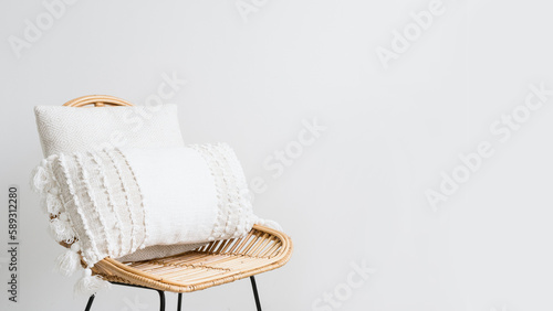 pillows from natural material in boho style on chair near wall