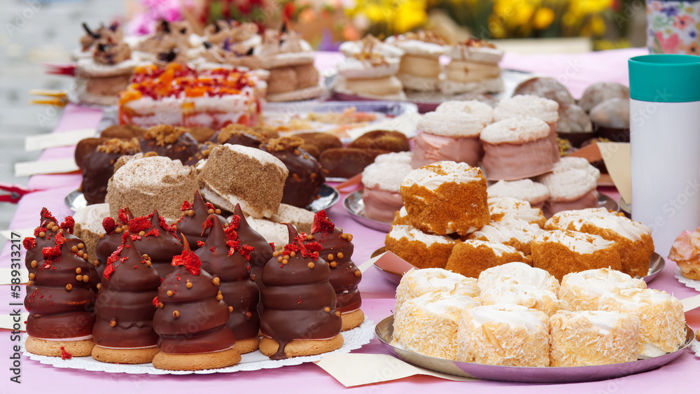 Sale of desserts and other goodies at the farmers street food market in Prague, stand of one of the local confectioners offering cakes and other desserts.