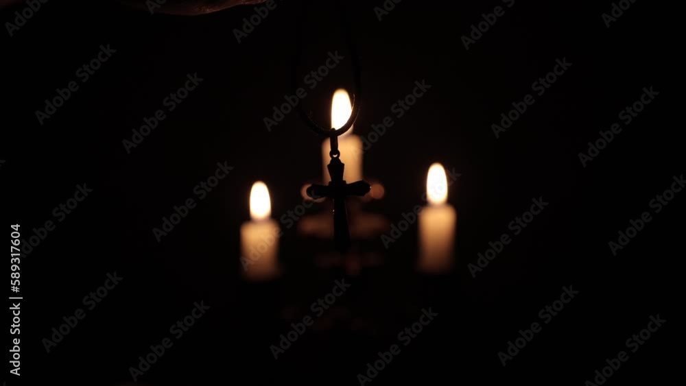 Candles in the dark. Cross on the background of candles. Prayer to God. Golden cross silhouette. Light in the night Candles in the dark. Cross on the background of candles. Prayer to God. Golden cross silhouette. Light in the night