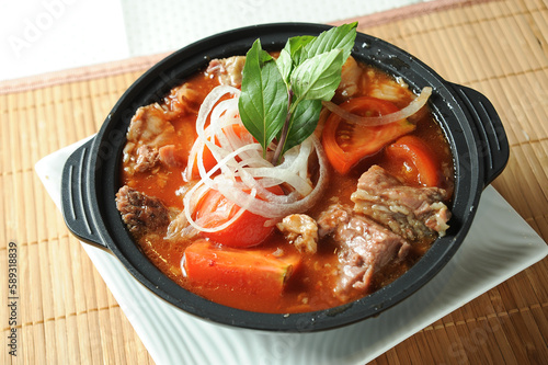 Tomato and Beef Brisket Casserole noodles served in borth isolated on table top view of Claypot