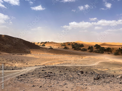 Merzouga, Morocco, Africa, panoramic road in the Sahara desert with view of the beautiful sand dunes, 4x4 trip, blue sky and white clouds