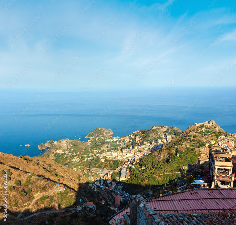 Beautiful Taormina sea coast panoramic view from  Castelmola mountain village and Castelmola roofs, Sicily, Italy. People unrecognizable.