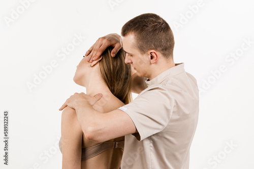 Manual therapy at physiotherapist or chiropractor. Orthopedist examining female neck and head. Manual correction of the ridge and cervical region. Rehabilitation therapy on white background. photo