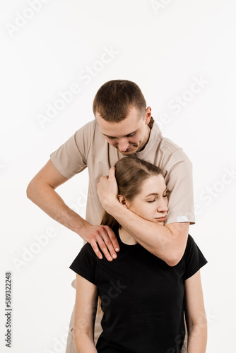 Orthopedist examining female neck and head. Manual correction of the ridge and cervical region. Rehabilitation therapy on white background. Manual therapy at physiotherapist or chiropractor.