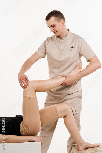 Knee joint and meniscus injury. Orthopedist is touching and pressing knee for assessment of the volume of physiological movements. Examination of knee mobilisations.