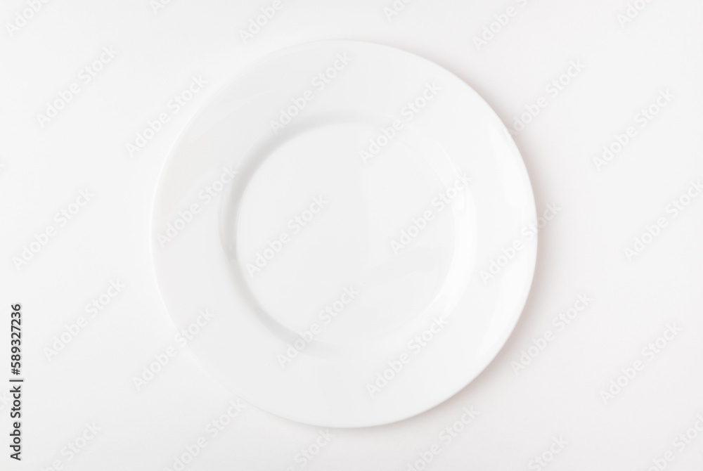 An empty white plate on a white background. Blank plate. Top view. An empty white plate on a white background. Blank plate. Top view.