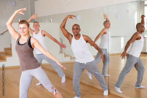 Men and ladies dancing aerobics at lesson in the dance class