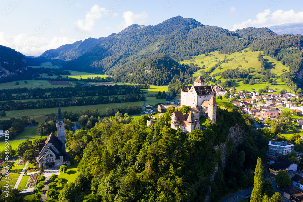 Scenic view from drone of medieval Gutenberg Castle on hilltop in Balzers village on sunny summer day, Liechtenstein