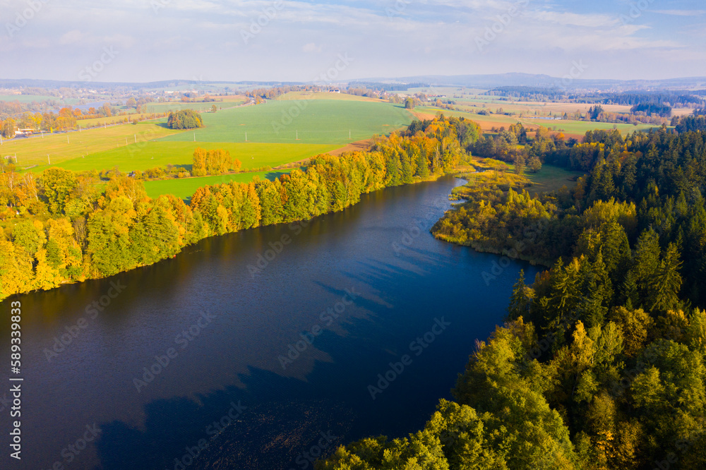 Impressive colorful autumn landscape of trees in park and river, view from drone