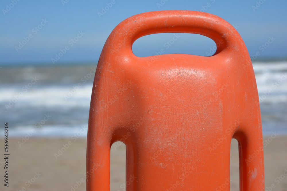 salbavidas de plastico naranja en primer plano con el mar de fondo. herramienta del guardavidas salbavidas de plastico naranja en primer plano con el mar de fondo. herramienta del guardavidas