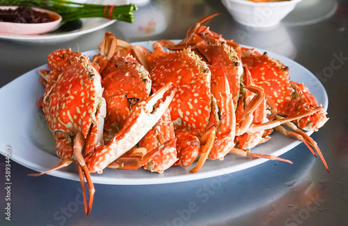 Fresh sea crabs cooked by charcoal grilling, served on the dish with Thai seafood dipping sauce at the famous local restaurant in Thailand.
