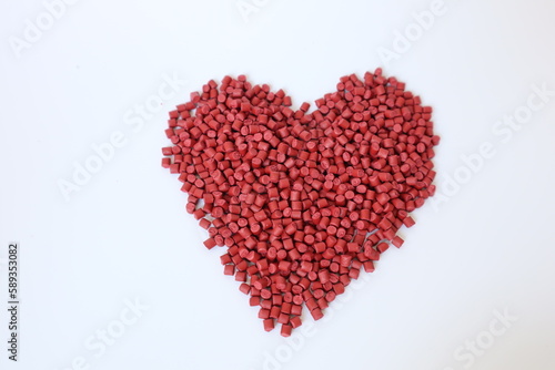 Red plastic pellets, rubber granules on a white background


