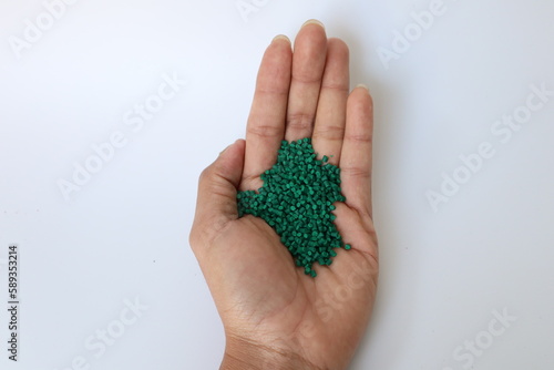 Primary color mix. Green plastic pellets, rubber granules on a white background