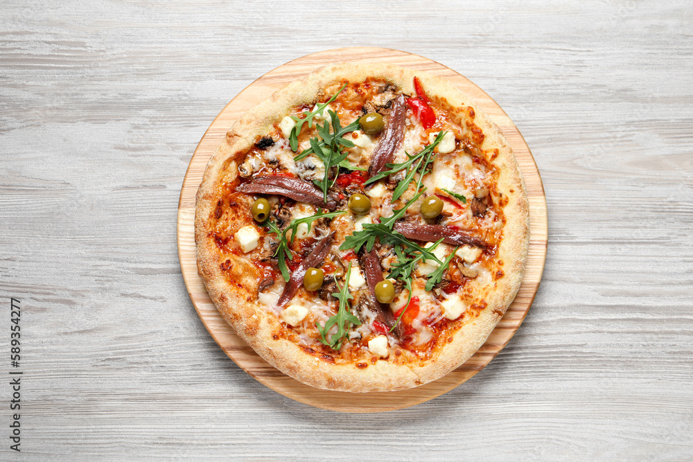 Tasty pizza with anchovies, arugula and olives on grey wooden table, top view Tasty pizza with anchovies, arugula and olives on grey wooden table, top view