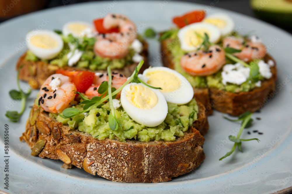 Delicious sandwiches with guacamole, shrimps and eggs on plate, closeup Delicious sandwiches with guacamole, shrimps and eggs on plate, closeup