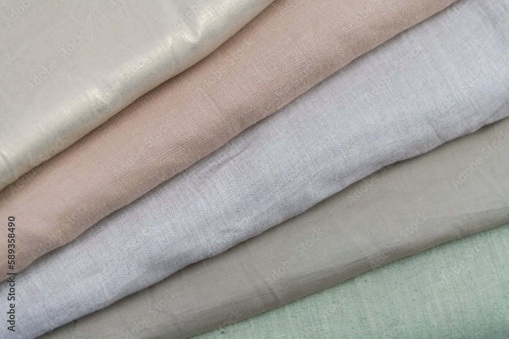 Collection of fashionable fabrics. Samples of different natural fabrics for sewing a fashion collection of clothes. Large selection of fabrics in the store or tailor warehouse. Collection of fashionable fabrics. Samples of different natural fabrics for sewing a fashion collection of clothes. Large selection of fabrics in the store or tailor warehouse.