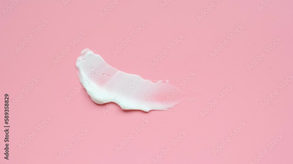 Smear of moisturizer moisturizing cream on pink background close-up, top view. Smear of moisturizer moisturizing cream on pink background close-up, top view.