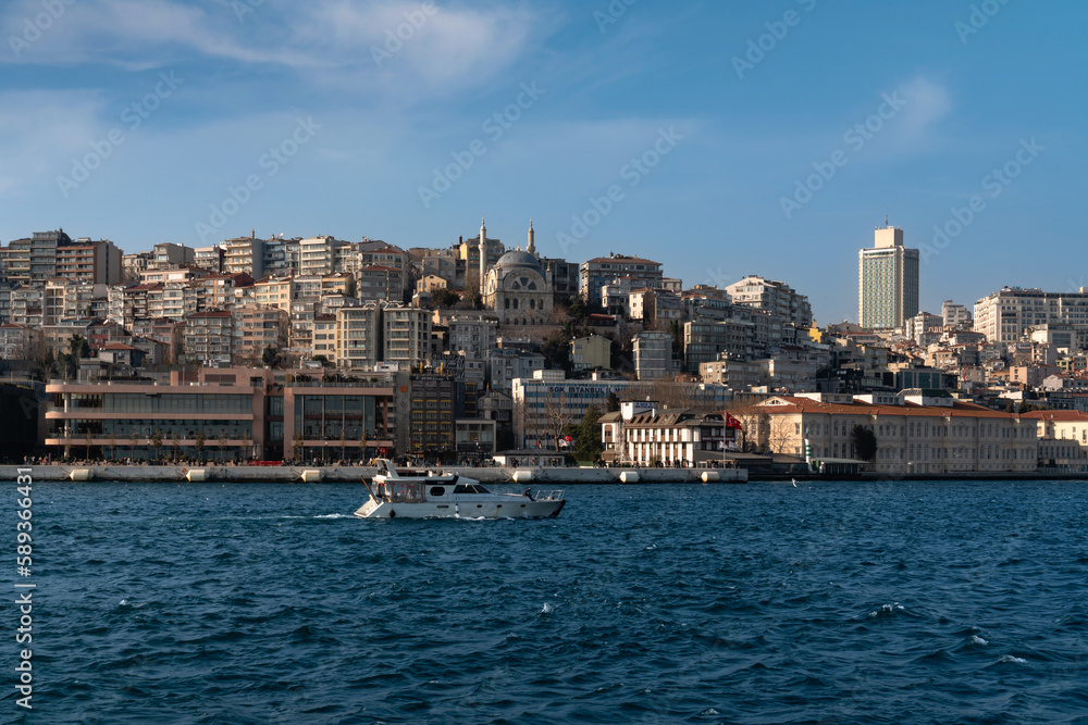 View of the embankment-boulevard of the Galataport shopping and entertainment center in the Karakey area and the Cihangir Mosque on a sunny day, Istanbul, Turkey
