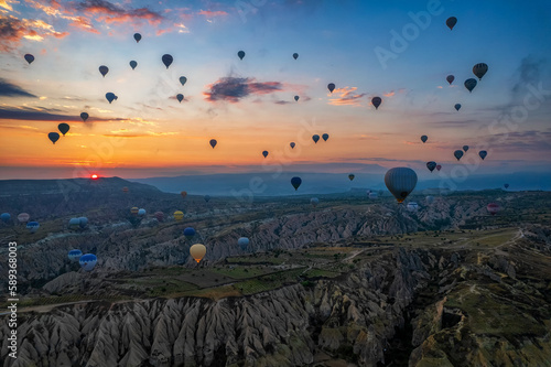 Sunrise panorama of famous Cappadocia landscape view with lots of hot air balloons flying