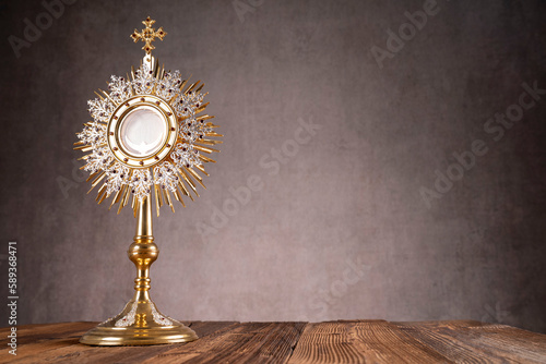 Catholic religion concept. Easter.The monstrance and golden chalice on gray background. 
