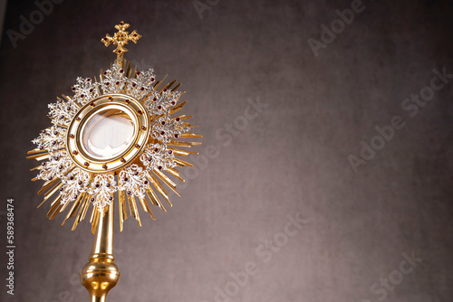 Catholic religion concept. Easter.The monstrance and golden chalice on gray background. 