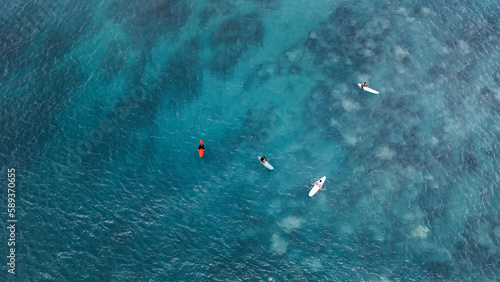 Photography Surfers in the blue transparent ocean in Hawaii from above, aerial drone shot