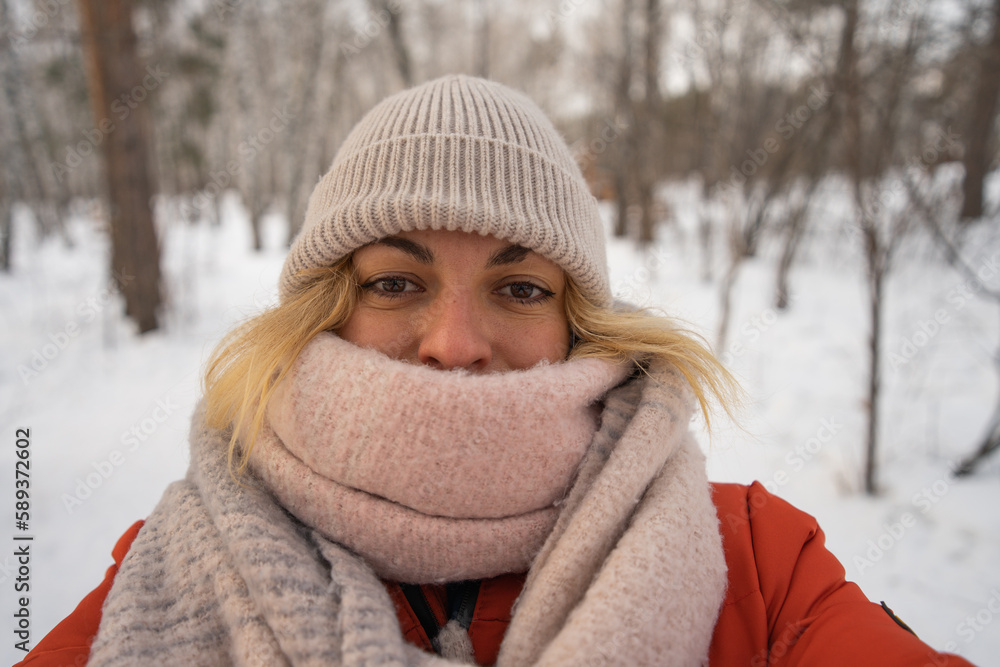 a girl in a hat and scarf gets cold in winter and takes a selfie a girl in a hat and scarf gets cold in winter and takes a selfie