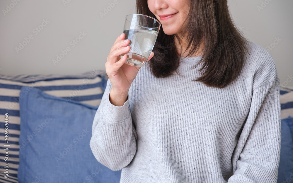 Closeup image of a young woman holding and drinking water Closeup image of a young woman holding and drinking water