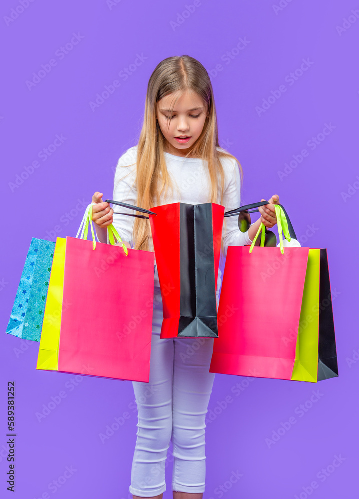 curious teen girl with shopping purchase isolated on purple. teen girl with shopping purchase