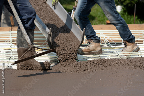 Workers pouring concrete to make a stamped floor