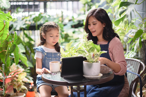 Homeschooling parents, Mother and daughter spending time together at the garden while using digital tablet for home school teaching.