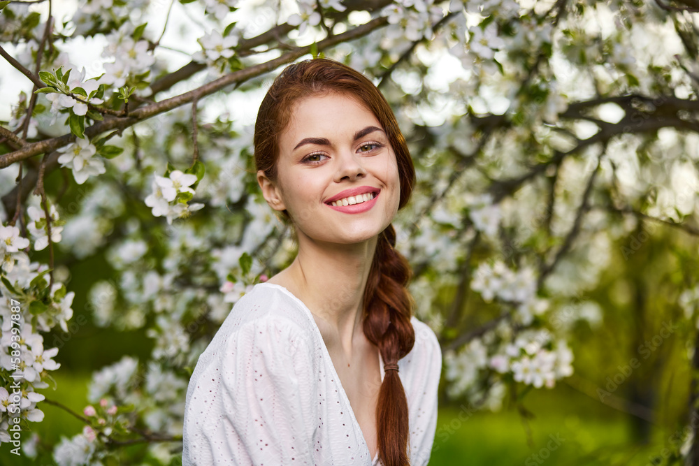Beautiful young woman. model in white dress stands in white flowers. Horizontal photo. copy space. Beautiful young woman. model in white dress stands in white flowers. Horizontal photo. copy space.