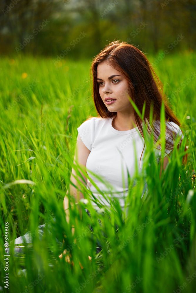 portrait of a joyful cute woman sitting in the grass portrait of a joyful cute woman sitting in the grass