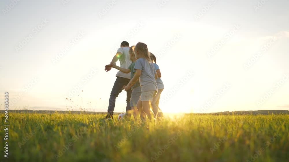 Happy family. group of cheerful children play ball with their father. Playing football with your family in park on sunny day. family is having fun with ball. concept of happy family, children, nature. Happy family. group of cheerful children play ball with their father. Playing football with your family in park on sunny day. family is having fun with ball. concept of happy family, children, nature.