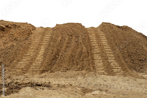 Isolate mounds of sandy brown soil that have been excavated and poured together with large backhoe wheels to prepare materials for filling and repairing roads in rural Thailand during the dry season.