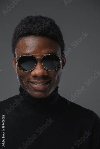 Portrait of stylish african guy with turtleneck sweater looking at camera. © Fxquadro