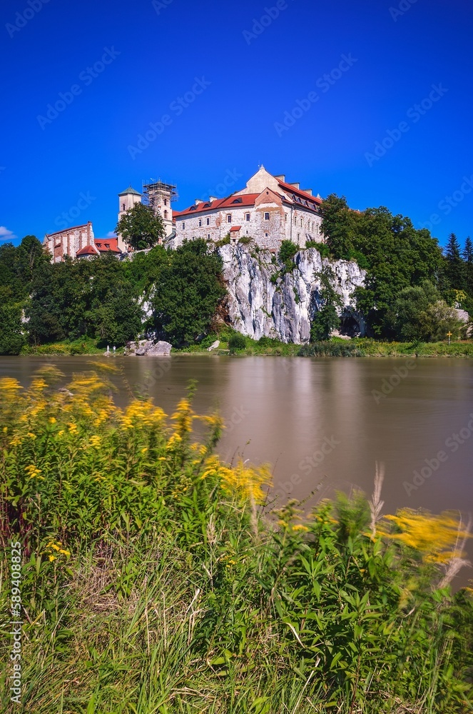 Beautiful historic monastery on the Vistula River in Poland.. Benedictine abbey in Tyniec near Krakow, Poland. Long exposure photo with blurred water effect.