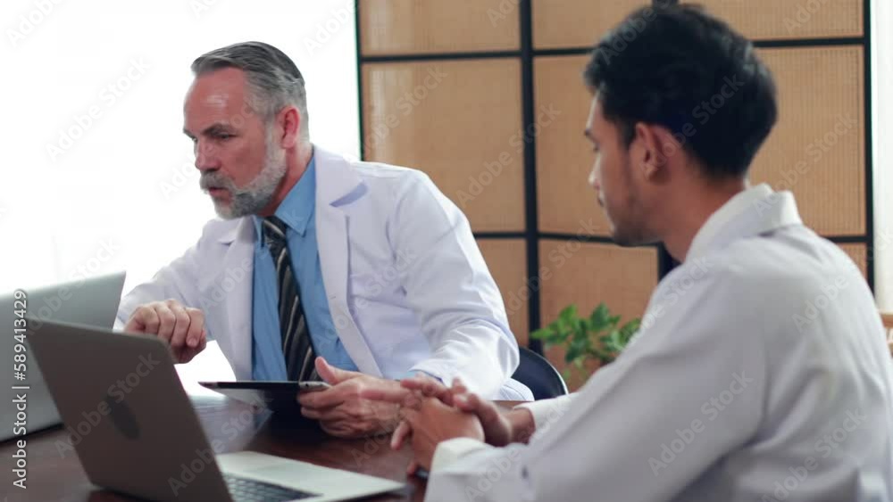senior caucasian doctor and young intern doctor having discussion about patient diagnosis on digital tablet computer at hospital outdoor senior caucasian doctor and young intern doctor having discussion about patient diagnosis on digital tablet computer at hospital outdoor