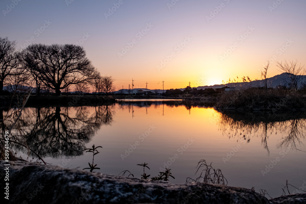 琵琶湖畔にある小さな池の夕暮れ　夕陽に染まる水面
