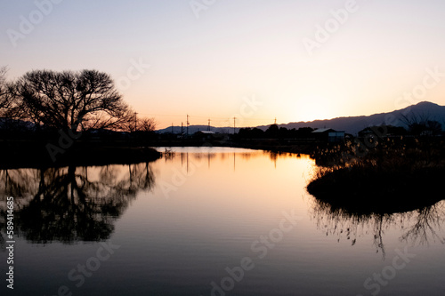 琵琶湖畔にある小さな池の夕暮れ 夕陽に染まる水面